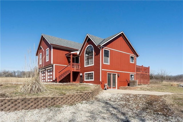 back of property featuring cooling unit and stairs