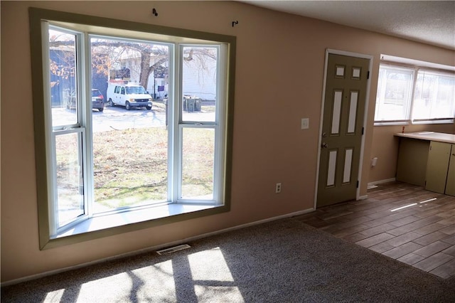 doorway to outside with visible vents, baseboards, and wood finished floors