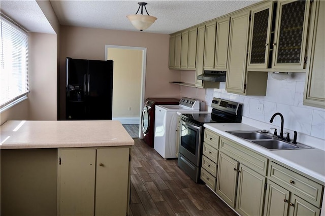 kitchen with under cabinet range hood, washer and clothes dryer, black fridge, stainless steel electric range, and a sink