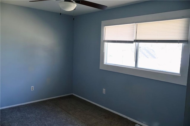 unfurnished room featuring baseboards, dark colored carpet, and ceiling fan