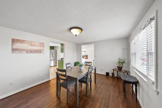 dining area with dark wood-style floors, a textured ceiling, and baseboards