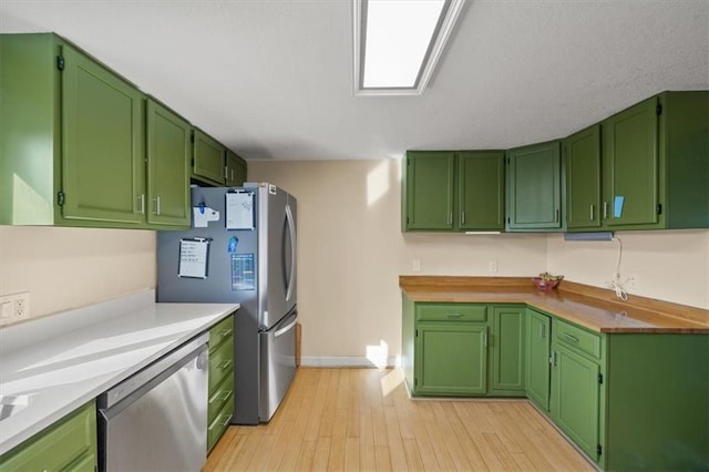 kitchen with light wood-style floors, baseboards, and appliances with stainless steel finishes