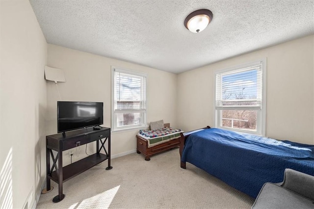 carpeted bedroom featuring baseboards and a textured ceiling