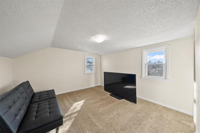 sitting room with a wealth of natural light, lofted ceiling, baseboards, and carpet floors