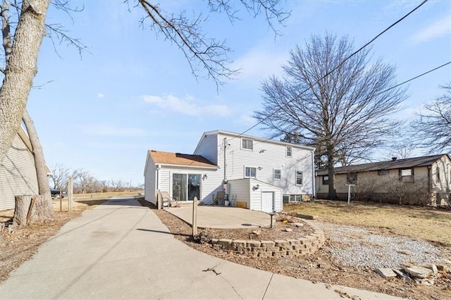 back of house with a patio area and driveway