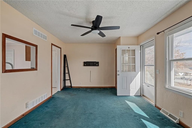 empty room featuring visible vents, a textured ceiling, and carpet floors