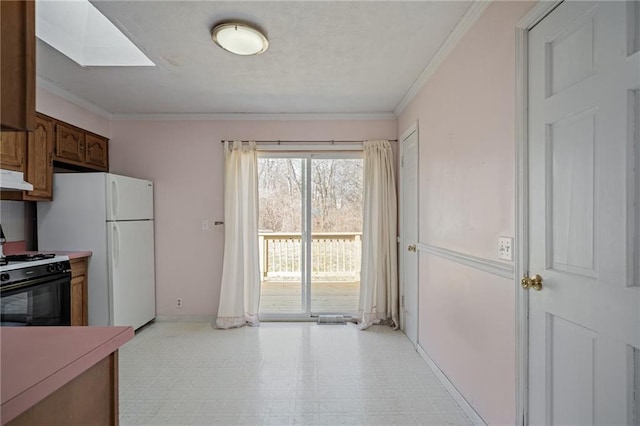 kitchen featuring under cabinet range hood, light floors, gas stove, and crown molding