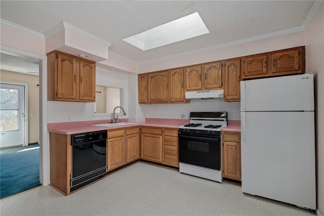 kitchen with a sink, under cabinet range hood, range with gas stovetop, freestanding refrigerator, and dishwasher