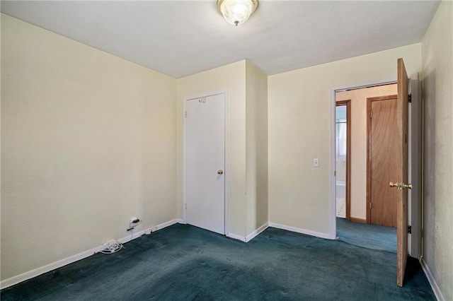 unfurnished bedroom featuring baseboards and dark carpet