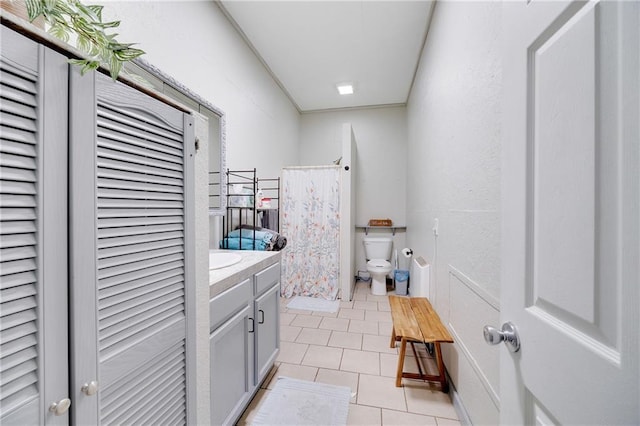 bathroom with tile patterned floors, toilet, curtained shower, a closet, and vanity