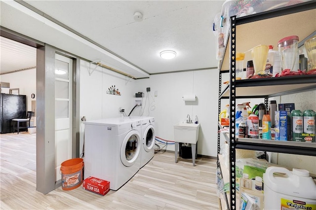 laundry area with washing machine and dryer, wood finished floors, and laundry area