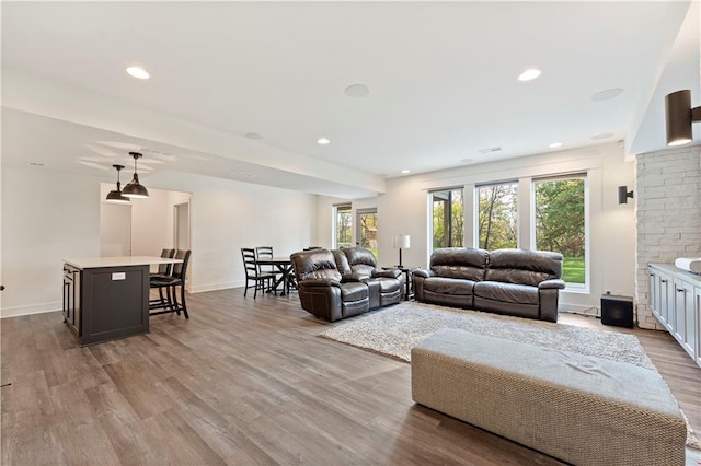 living room featuring recessed lighting, baseboards, and wood finished floors