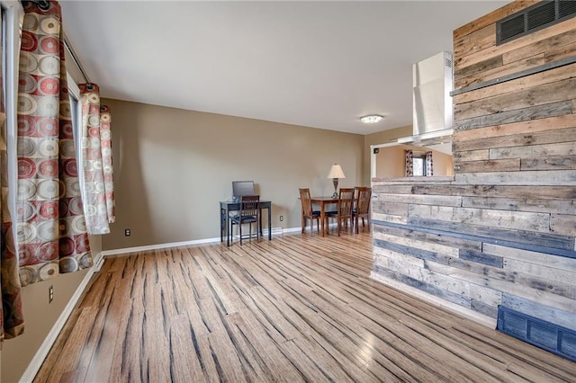 unfurnished room featuring wood finished floors, visible vents, and baseboards