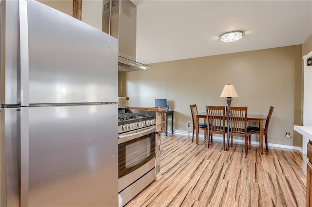 kitchen featuring wood finished floors, baseboards, and appliances with stainless steel finishes