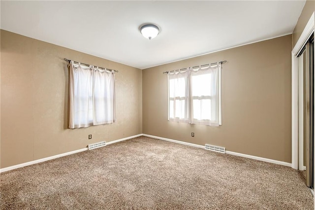 unfurnished bedroom with visible vents, baseboards, carpet floors, and a closet