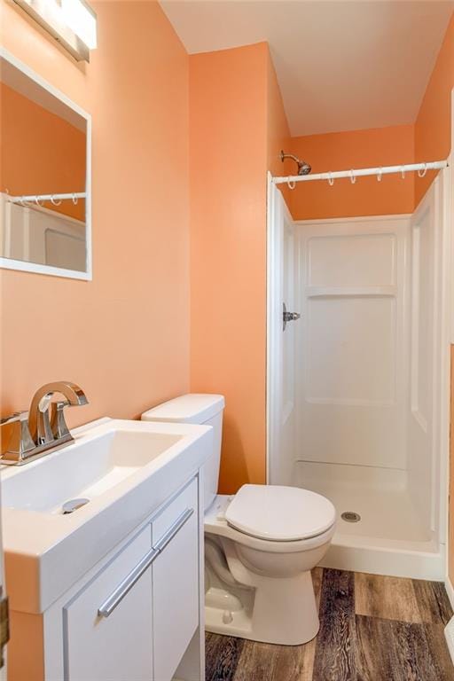 full bath featuring a shower, toilet, wood finished floors, and vanity