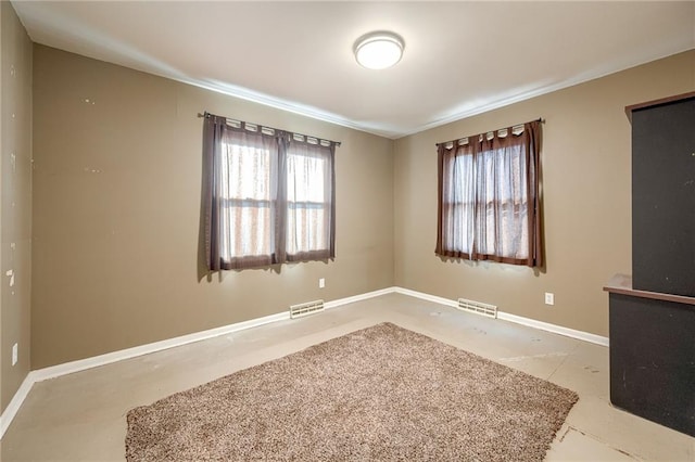 unfurnished room featuring visible vents and baseboards