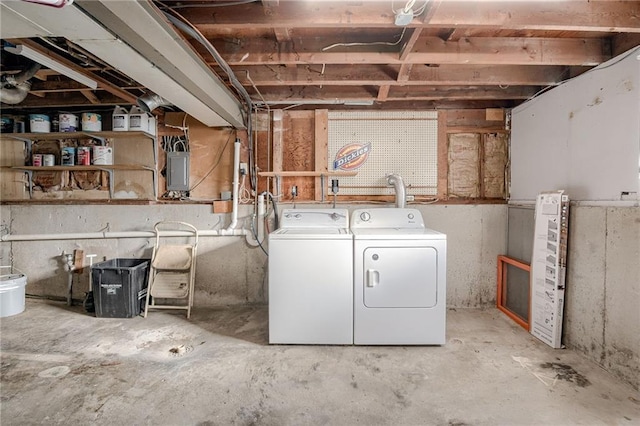 unfinished basement featuring electric panel and separate washer and dryer