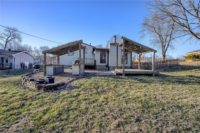 rear view of property with a yard, a deck, and fence