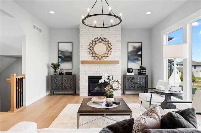 8017 Round Prairie St, Shawnee, KS 66220 - living room featuring a chandelier, wood finished floors, recessed lighting, and a brick fireplace