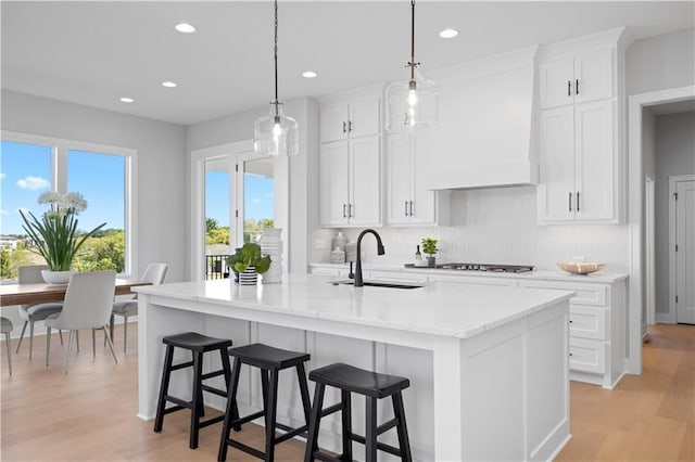 8017 Round Prairie St, Shawnee, KS 66220 - kitchen with tasteful backsplash, custom exhaust hood, recessed lighting, light stone counters, and white cabinets