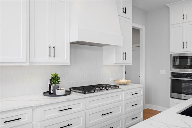 8017 Round Prairie St, Shawnee, KS 66220 - kitchen with appliances with stainless steel finishes, custom range hood, backsplash, and white cabinets