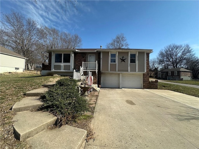 raised ranch featuring concrete driveway, an attached garage, covered porch, and brick siding