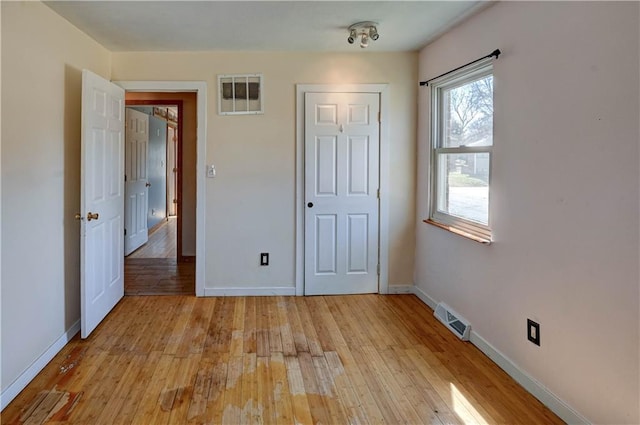 unfurnished bedroom featuring visible vents, baseboards, and light wood-style floors