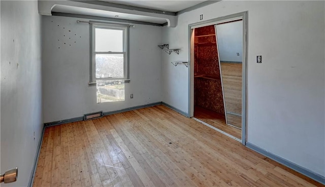 empty room featuring baseboards, plenty of natural light, and hardwood / wood-style floors