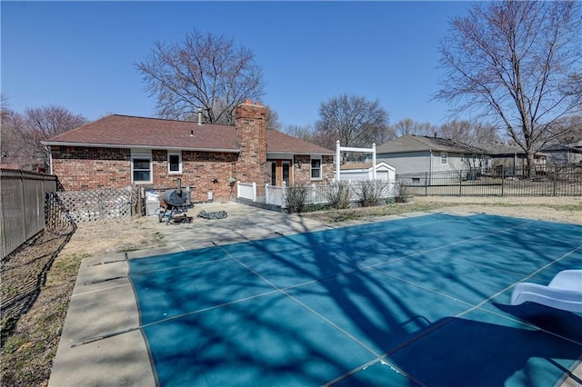 view of swimming pool with a fenced backyard and a patio