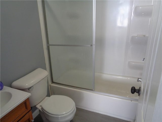 full bathroom featuring shower / bath combination with glass door, toilet, and vanity