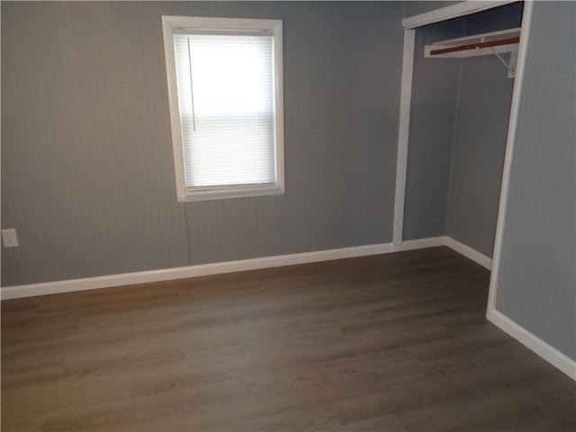 unfurnished bedroom with a closet, baseboards, and wood finished floors