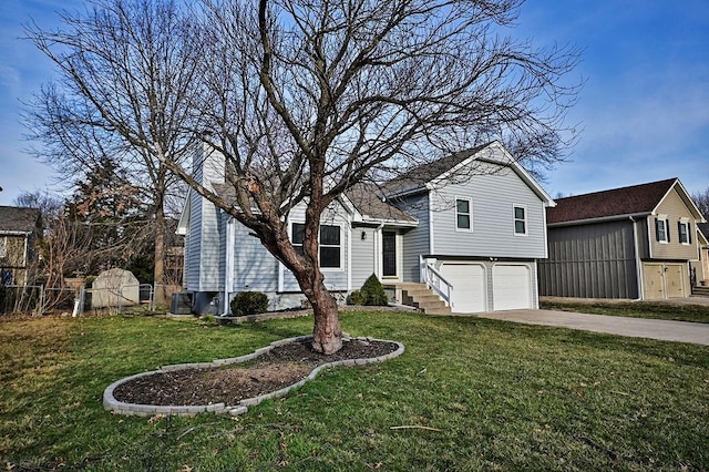 tri-level home with driveway, an attached garage, a front lawn, and fence