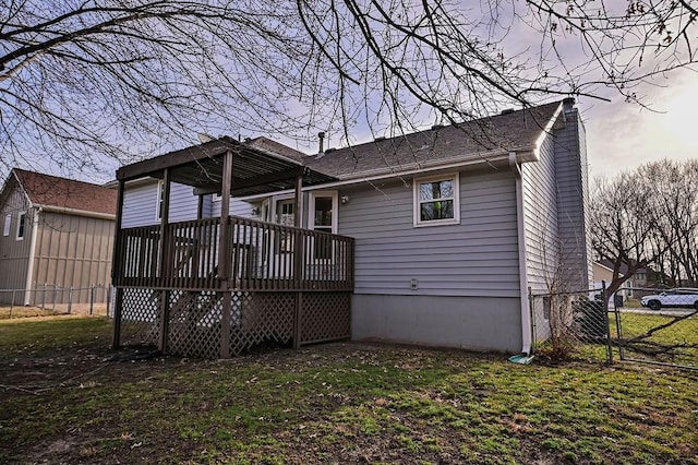 back of house with a yard, a deck, and fence