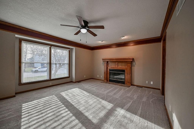 unfurnished living room featuring baseboards, carpet, a fireplace with flush hearth, ornamental molding, and a textured ceiling