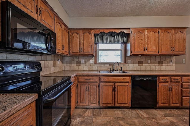 kitchen with black appliances, a sink, tasteful backsplash, a textured ceiling, and brown cabinetry