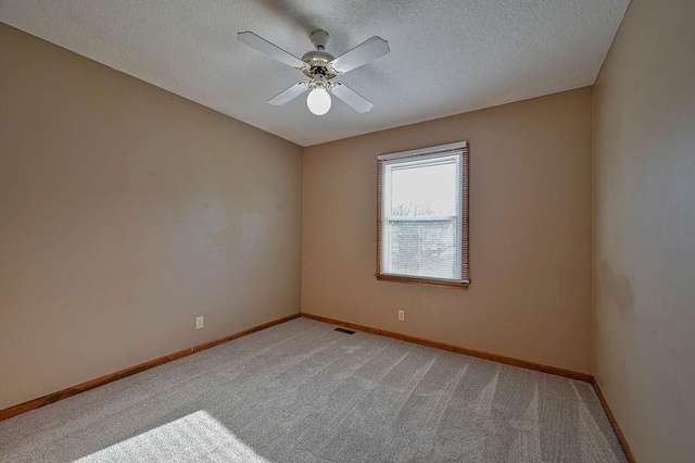 empty room featuring baseboards, light carpet, and a textured ceiling