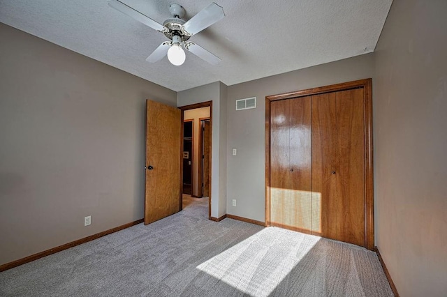 unfurnished bedroom featuring baseboards, visible vents, ceiling fan, a textured ceiling, and carpet flooring