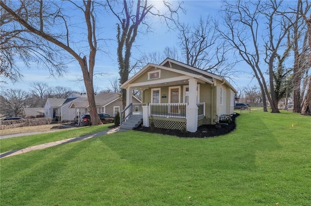 bungalow-style home featuring covered porch and a front yard