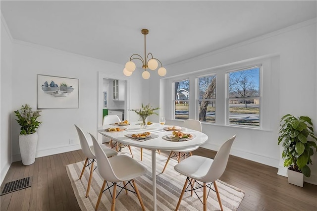 dining area with visible vents, crown molding, baseboards, a chandelier, and wood-type flooring