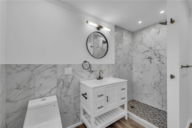 bathroom with a marble finish shower, toilet, recessed lighting, wood finished floors, and vanity