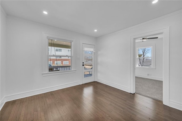 spare room with recessed lighting, baseboards, ornamental molding, and dark wood-style flooring