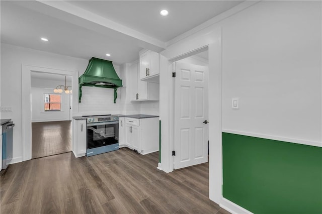 kitchen with premium range hood, dark wood-type flooring, backsplash, appliances with stainless steel finishes, and white cabinets