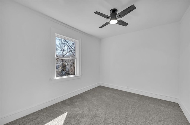 carpeted empty room featuring a ceiling fan and baseboards