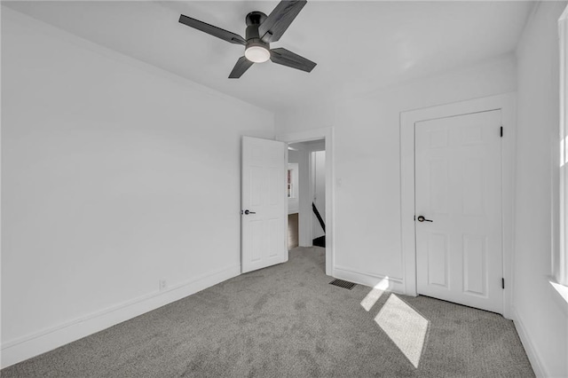 unfurnished bedroom featuring visible vents, a ceiling fan, baseboards, and carpet floors