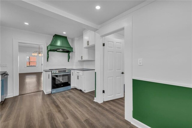 1901 E 79th St, Kansas City, MO 64132 - kitchen featuring dark wood finished floors, custom exhaust hood, stainless steel appliances, white cabinets, and tasteful backsplash