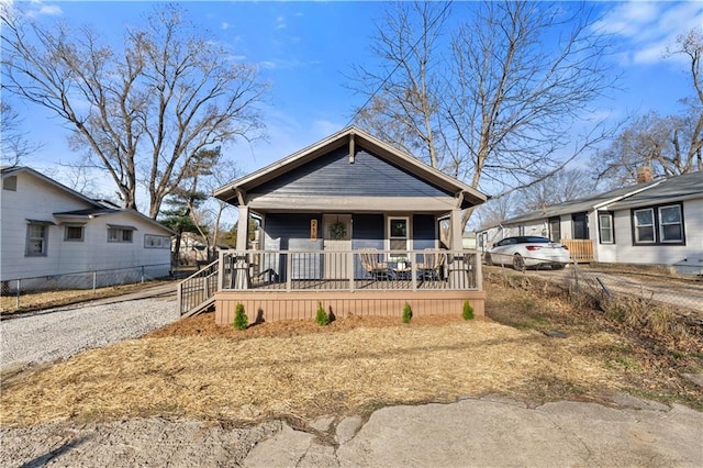 view of front of house with a porch, driveway, and fence