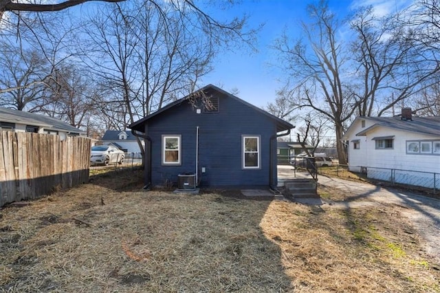 back of house with cooling unit and fence