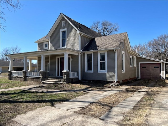 view of front facade with a garage, covered porch, and a shingled roof