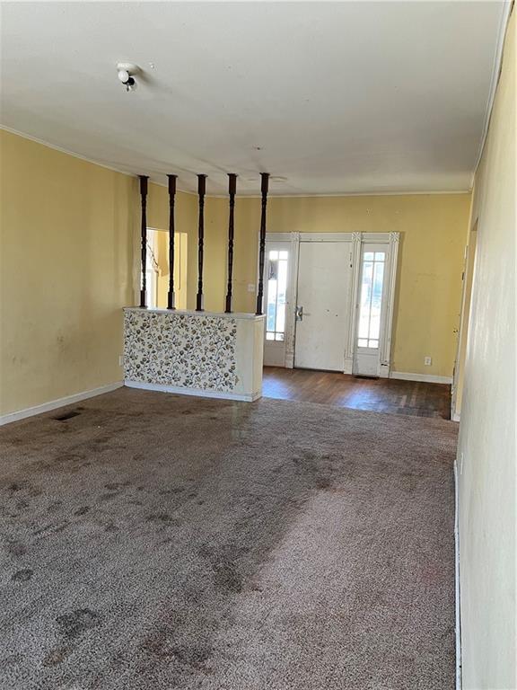 foyer with baseboards and carpet floors